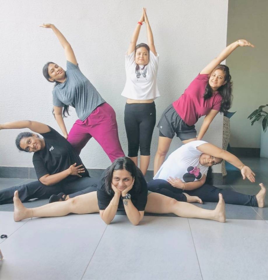 Group of women in synchronized yoga stretches