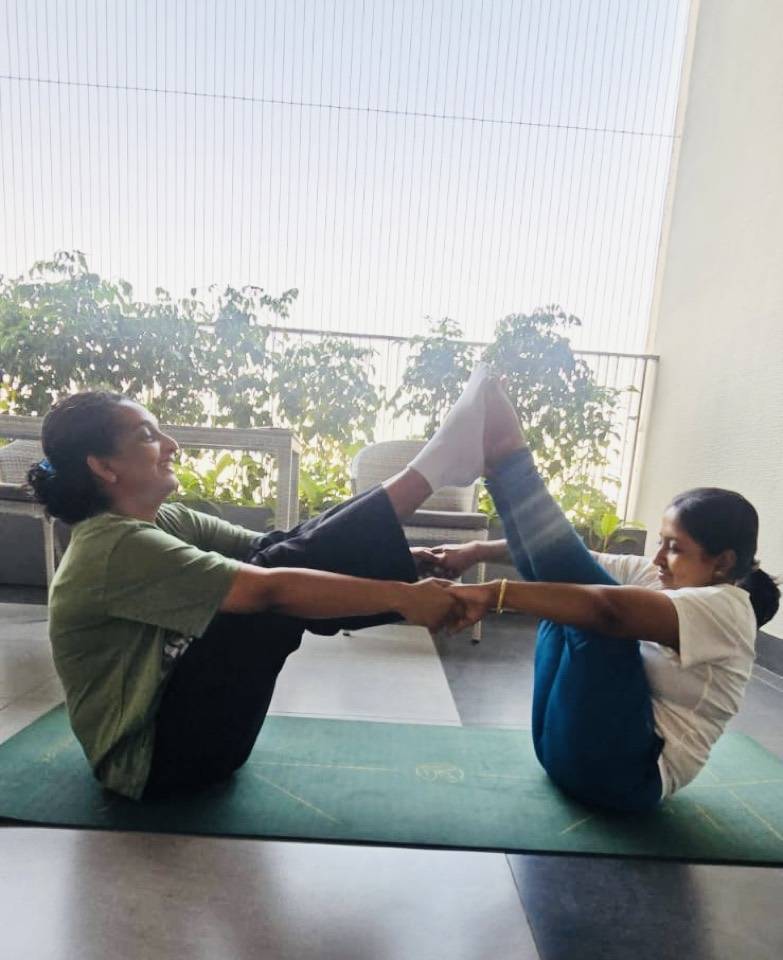 Partner boat pose on an outdoor terrace
