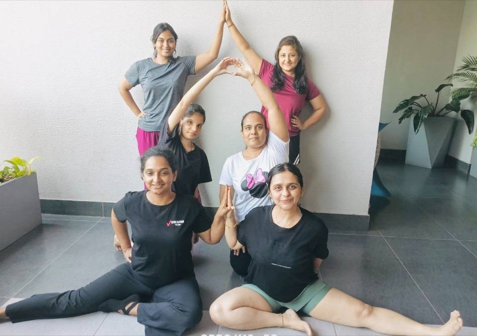 Group forming a heart shape with arms during yoga
