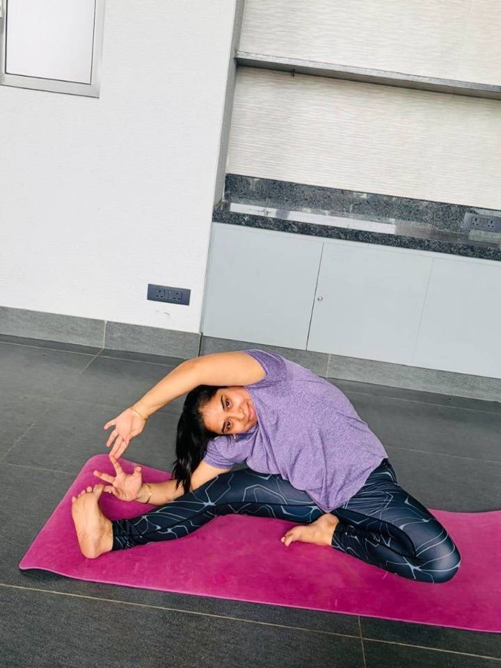 Student in a seated side stretch on a yoga mat