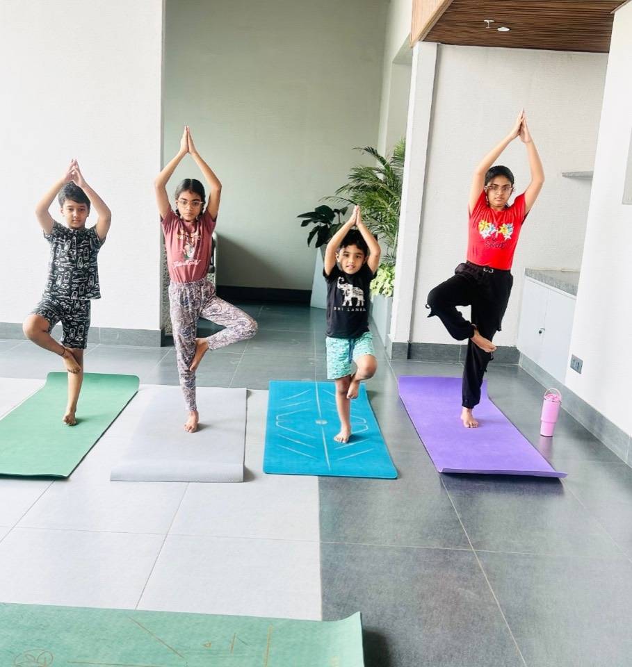 Kids class practicing tree pose on yoga mats